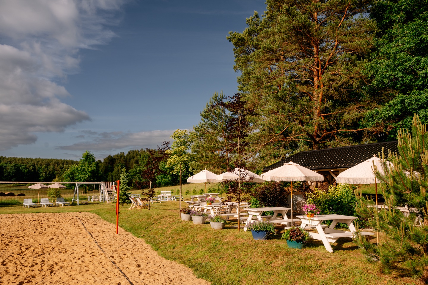 Boisko do siatkówki plażowej i stoliki z parasolami
